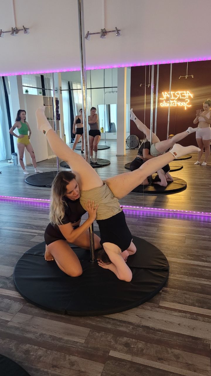 Trainerin unterstützt eine Teilnehmerin beim Stretching in der Probestunde